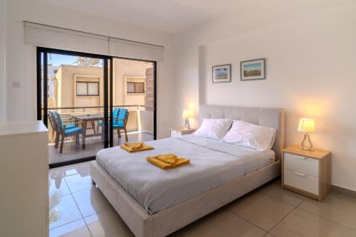 a bedroom with a bed and a balcony with a table at Lazaros 1BDR Suite 3 min walk to Finikoudes beach in Larnaca