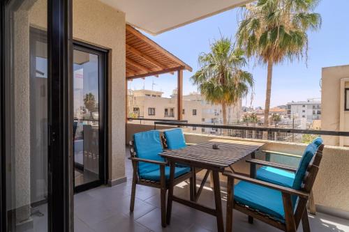 a patio with a table and chairs on a balcony at Lazaros 1BDR Suite 3 min walk to Finikoudes beach in Larnaca