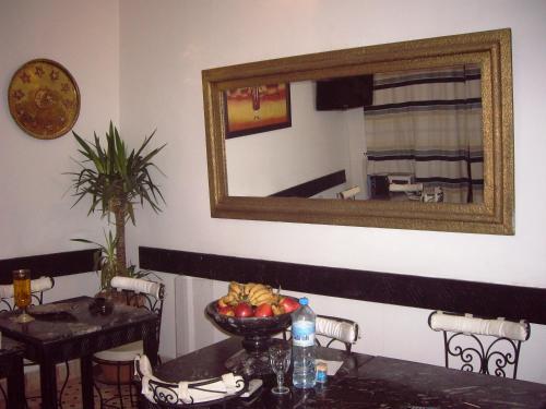 een spiegel aan de muur met een tafel met een fruitschaal bij Ryad Laârouss in Marrakesh