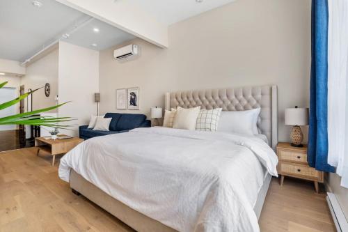 a bedroom with a large bed and a blue couch at Central King Studio in Montreal