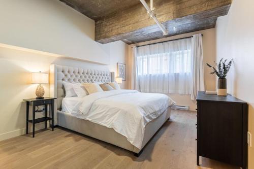 a bedroom with a large bed and a window at Double King Luxury 2BR Condo in Montréal