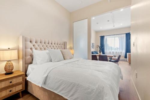 モントリオールにあるDowntown 2BR condoの大きな白いベッドと机のある寝室
