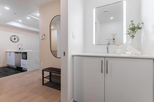 a white bathroom with a sink and a mirror at Double King Luxury 2BR Condo in Montréal