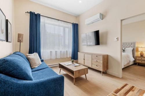 a living room with a blue couch and a mirror at Downtown 2BR Suite in Montréal