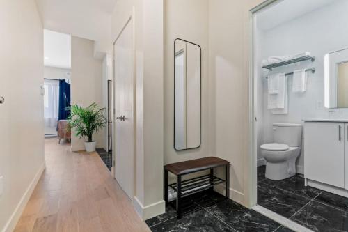 a bathroom with a toilet and a mirror at City Center 2BR Condo in Montreal