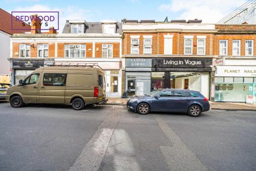 a van and a car parked on a city street at PENTHOUSE SERVICED APARTMENT IN CAMBERLEY TOWN CENTRE, WITH FREE PARKING, FREE WiFi, LIFT AND BALCONY ACCESS, PERFECT FOR BUSINESS STAYS, FAMILIES, RELOCATIONS, EXTENDED STAYS, AND EMERGENCY ACCOMMODATION by REDWOOD STAYS in Camberley