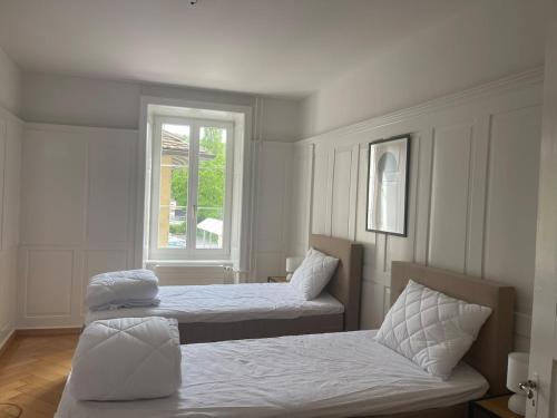 a bedroom with two beds and a window at The R Apartment Munot - Old Town in Schaffhausen