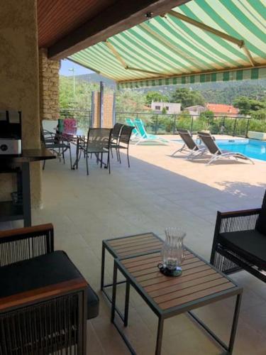 un patio avec une table et des chaises et une piscine dans l'établissement La Villa d'Antan, à Nyons