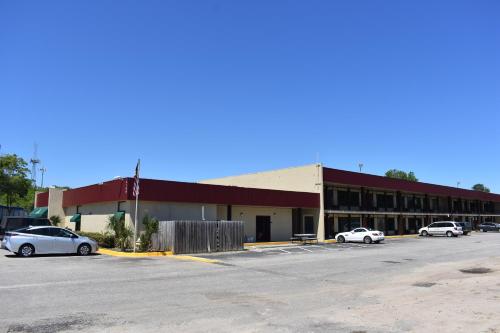 a building with three cars parked in a parking lot at Stay Express Inn North Charleston in Charleston
