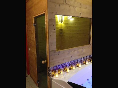 a bathroom with a tub and a large mirror at Le Studio - Saint Jean de Maurienne in Saint-Jean-de-Maurienne