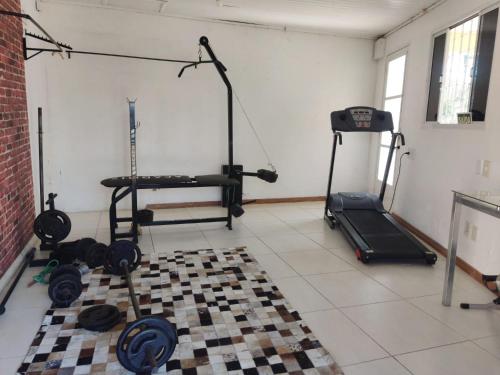 a room with a gym with weights and a treadmill at Hotel Alvorada in Alegrete