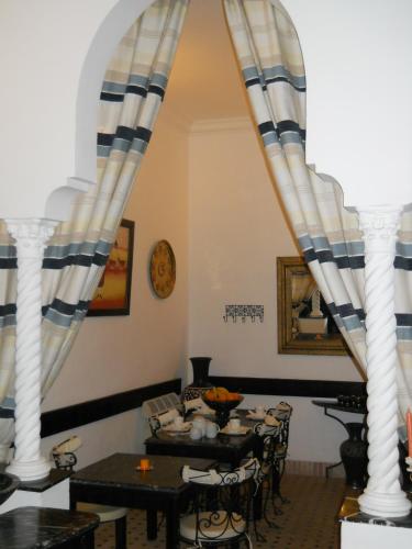 een eetkamer met witte zuilen en tafels bij Ryad Laârouss in Marrakesh