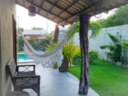 a hammock hanging from a pergola in a garden at Chalés Refúgio Fortim in Fortim