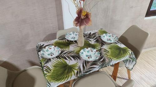 a table with four plates and a flower on it at Guest House Stevovski in Ohrid
