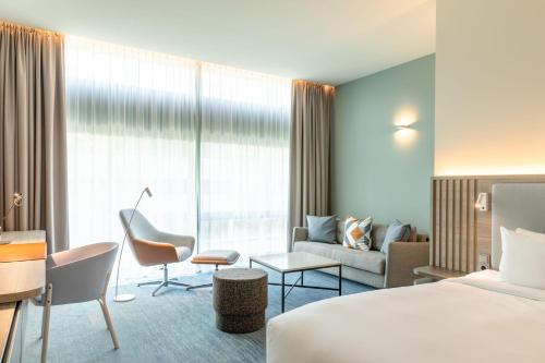a hotel room with a bed and a couch at Courtyard by Marriott Amsterdam Arena Atlas in Amsterdam