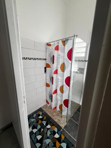a bathroom with a shower with a shower curtain at Appartement Jayden in La Trinité