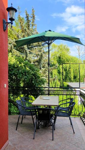 a table and chairs with an umbrella on a patio at Puszczykowska willa in Puszczykowo