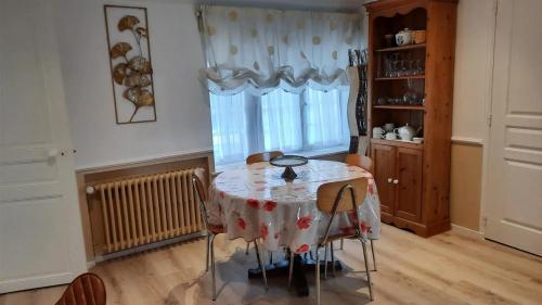 d'une salle à manger avec une table, des chaises et une fenêtre. dans l'établissement Maison charmante à Saint-Martin-des-Entrées, à Saint-Martin-des-Entrées
