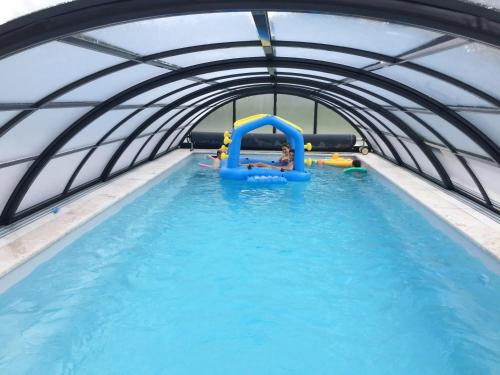 a child on a raft in a swimming pool at Maison charmante à Saint-Martin-des-Entrées in Saint-Martin-des-Entrées