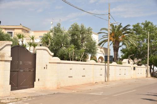 a brick fence with a gate in front of a house at Villa Luis in Fasano