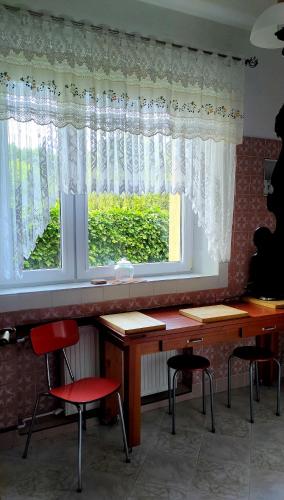 a table and chairs in front of a window at Puszczykowska willa in Puszczykowo
