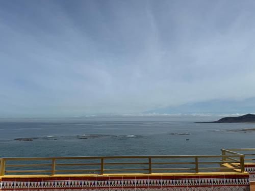Un banco amarillo en la parte superior de un edificio con vistas al agua. en Los Gueldes, en Las Palmas de Gran Canaria