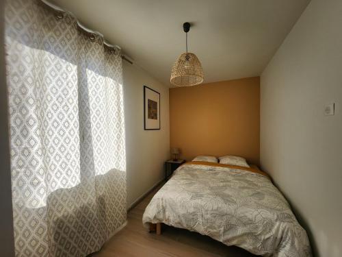 une chambre avec un lit et une grande fenêtre dans l'établissement La casa choukie, à Pornic