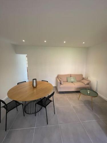 un salon avec une table et un canapé dans l'établissement Charmante dépendance avec jardin, à Vaux-sur-Seine