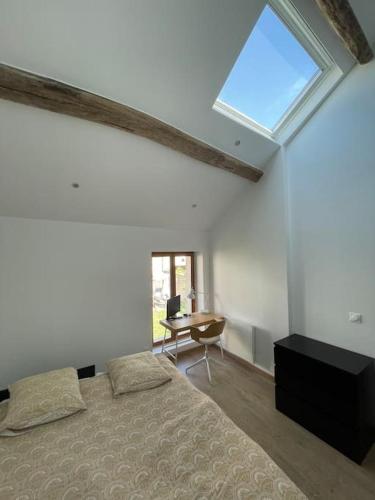 une chambre avec un lit, un bureau et une fenêtre dans l'établissement Charmante dépendance avec jardin, à Vaux-sur-Seine