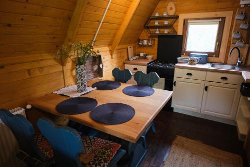 a kitchen with a wooden table with blue chairs at Bieszczadzka Samotnia in Cisna