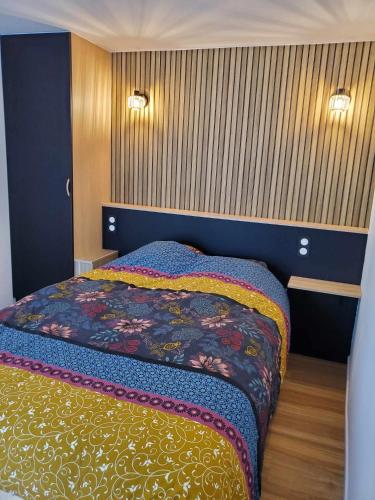 - une chambre avec un lit et une couverture colorée dans l'établissement Proche RER B et université Paris Saclay, à Orsay