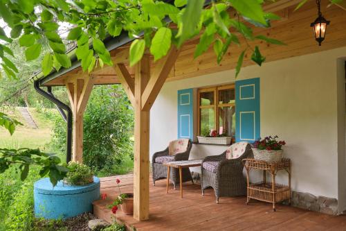 a pergola on a deck with chairs and a table at Bieszczadzka Samotnia in Cisna