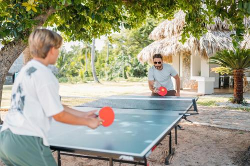 two men playing ping pong on a ping pong table at Wyndham Alltra Samana All Inclusive Resort in Las Galeras
