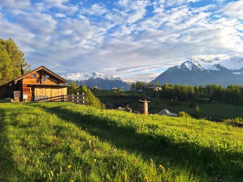 a cabin on a hill with mountains in the background at Chalet Bergtraum in Eischoll