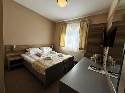 a hotel room with a bed and a desk at Rooms Comfor in Bihać