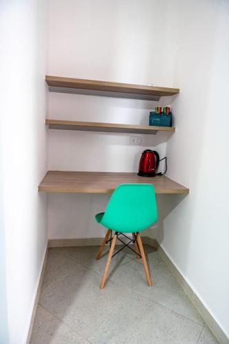 a green chair sitting in front of a desk at Hotel Boutique Campestre in Florencia
