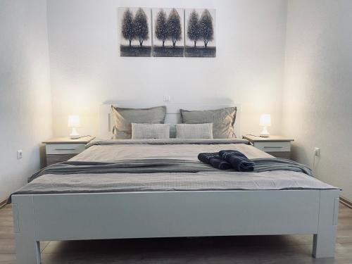 a bedroom with a white bed with two lamps at Apartman Kiss in Jajce