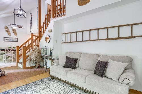 a living room with a couch and a staircase at Alden Home with Fire Pit Steps to Torch Lake! in Alden