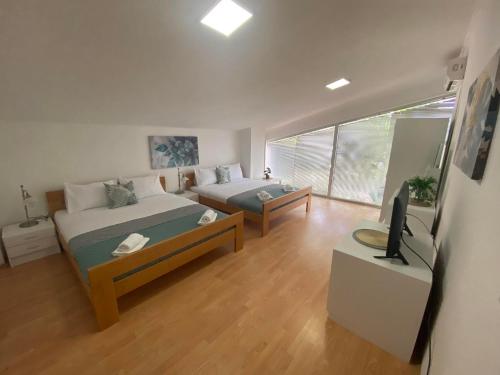 a bedroom with two beds and a tv in it at SIENA Apartment in Gevgelija