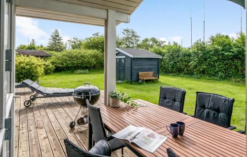 a wooden deck with a table and chairs on a backyard at Cozy Home In Gedser With Wifi in Gedser