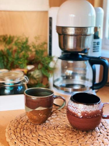 two coffee cups sitting on a counter with a mixer at Renovated Spartan BB in Austin