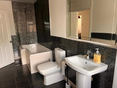 a bathroom with a white toilet and a sink at Amani Bungalow in Brandon