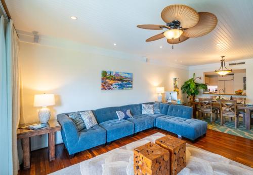 a living room with a blue couch and a table at Stunning Luxurious Ocean Villa with Ocean Views From All bedrooms. in Kahuku