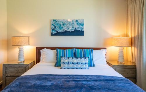 a bedroom with a bed with two lamps at Stunning Luxurious Ocean Villa with Ocean Views From All bedrooms. in Kahuku