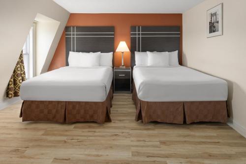 a hotel room with two beds and a lamp at Wildwood Inn Hotel Travelodge Beach & Boardwalk in Wildwood