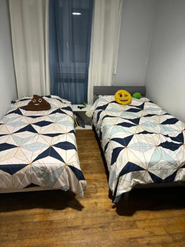 deux lits côte à côte dans une chambre dans l'établissement Maison pour les 24 h du Mans, à Arnage
