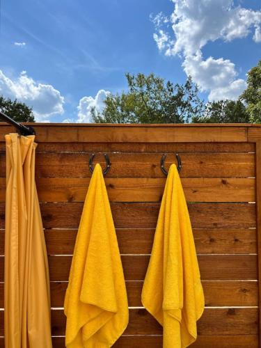 two yellow towels hanging on a wooden fence at Silo House "Opal" in Austin