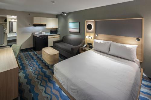 a hotel room with a large bed and a chair at Accent Inns Victoria in Victoria