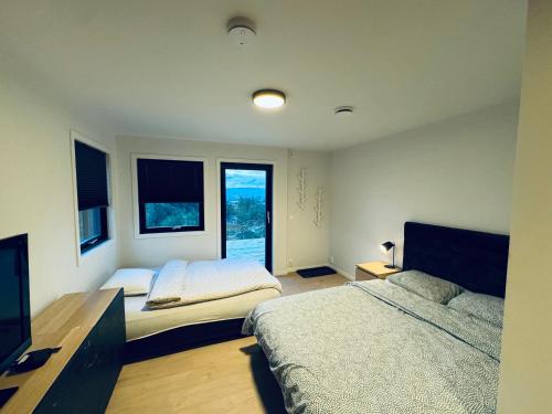 a bedroom with two beds and a flat screen tv at Ny og moderne studio leilighet ! in Fetsund