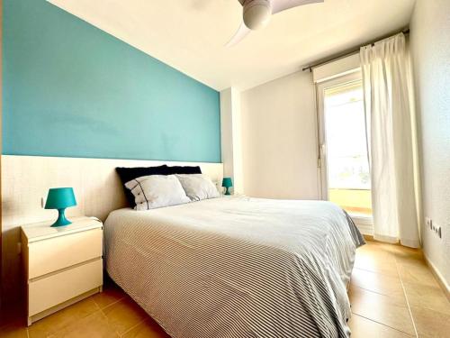 a bedroom with a bed and a blue wall at Mar y desconexión in San Javier
